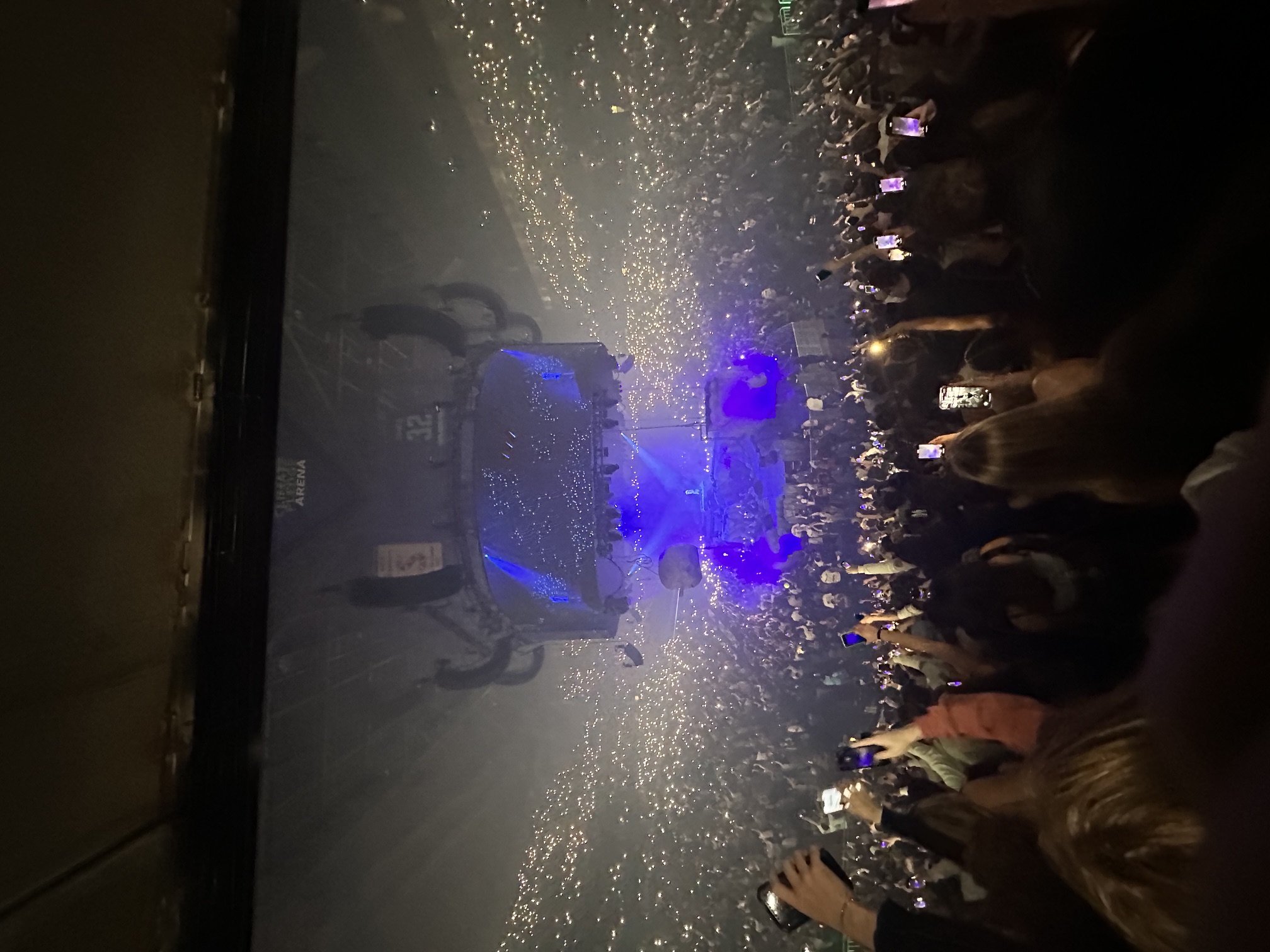 Arena show, stage and crowd lit blue with confetti